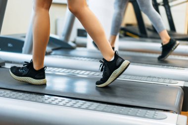 Genç bir kadın GYM 'de fitness yapıyor. Koşu bandında bir kadın.