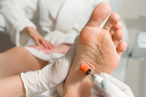 Lekarz podiatra, wykonuje zabieg leczenia kobiecych nóg. Zabiegi kosmetyczne stóp — Zdjęcie stockowe