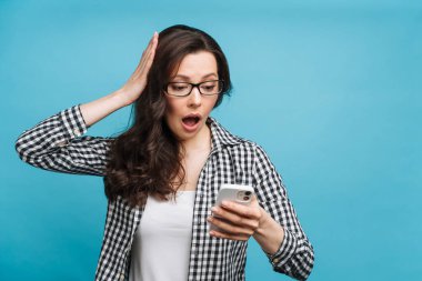 Kötü haberi öğrenen üzgün kadın. Mali kayıp, bir işletmenin iflası, döviz kurunda düşüş. Esmer, akıllı telefon ekranına bakıyor..