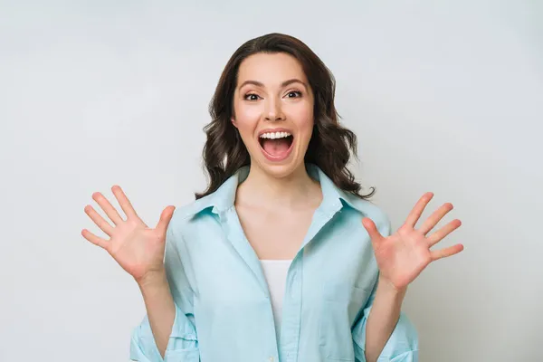 Alegre mujer joven positiva levantando los puños con expresión sonriente encantada —  Fotos de Stock