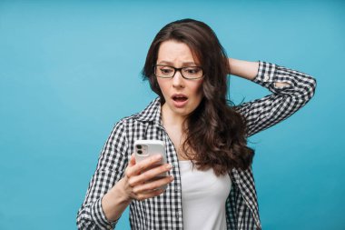 Kötü haberi öğrenen üzgün kadın. Mali kayıp, bir işletmenin iflası, döviz kurunda düşüş. Esmer, akıllı telefon ekranına bakıyor..