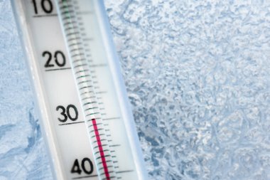 Termometre eksi 30 santigrat derece gösteriyor. Hava tahmini. Soğuk bir gün ve camda buz desenleri.