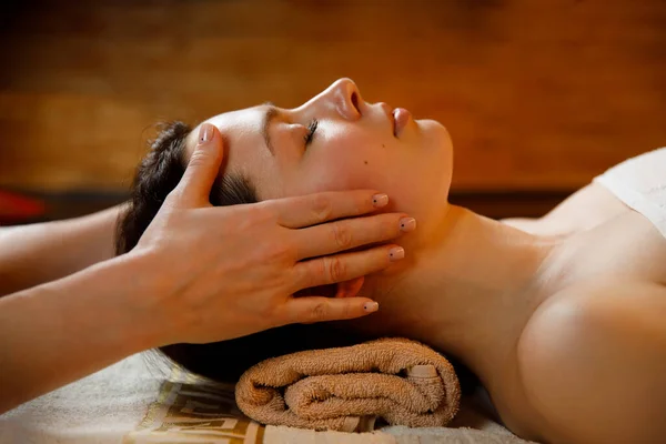 Jonge vrouw in een spa salon. Gezichtsmassage. — Stockfoto