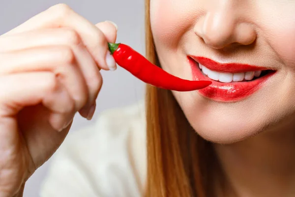 Vrouw met chili rode peper geïsoleerd en blauwe achtergrond. Sexy vrouwelijke lippen. Heet verleidelijk meisje. — Stockfoto