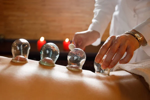 Een jonge vrouw ontspant in een massagesalon. Stofzuigers van medische cupping therapie op vrouw terug, close-up, Chinese geneeskunde. — Stockfoto