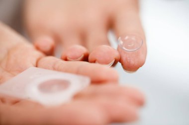 Genç bir kadın kontak lens kullanır..