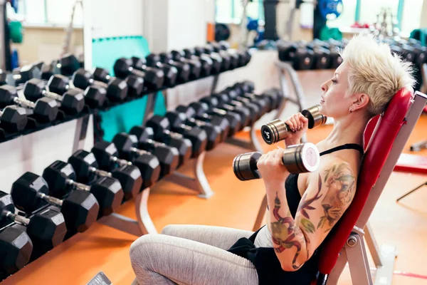 Eine junge Frau übt sich im Fitnesstraining am Gymnasium. — Stockfoto