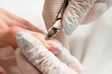 Tırnak törpüsü takan bir güzellik uzmanı manikür yaptırıyor. Güzellik ve el bakımı..