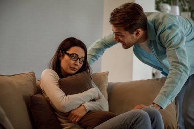 Genç çiftin tartışmaları, kötü ilişkileri var. Kızgın adamlar bir kadına bağırır..