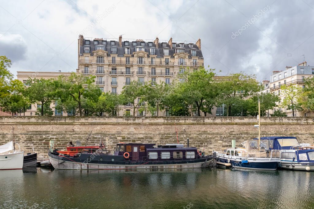 Paris, Bastille, beautiful harbor with houseboats, and typical facade in background