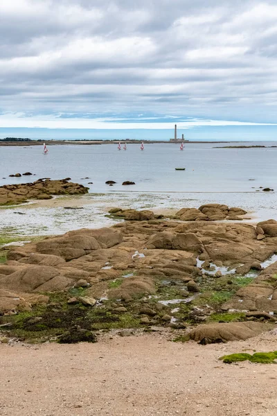 Normandiya 'daki Barfleur, arka planda Gatteville deniz feneri olan plaj.