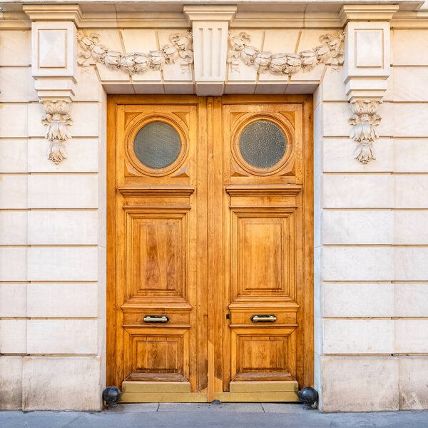 Париж, старинная деревянная дверь, красивый украшенный фасад в 11e округе