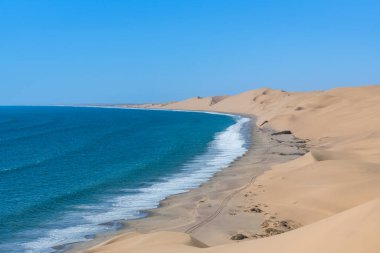 Namibya, Namib Çölü, denize düşen sarı kum tepelerinin manzarası.