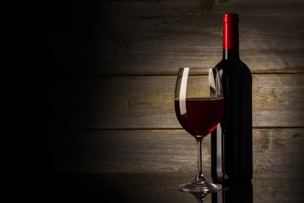 Vin glas och flaska på en trä bakgrund — Stockfoto