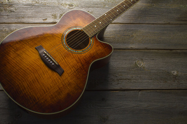Acoustic guitar on wood background