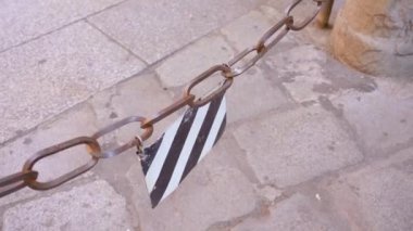 Metal tabela büyük paslı zincir üzerinde asılı. Yani giriş yasaktır.