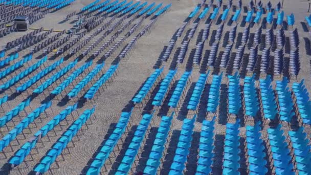 도시의 구경꾼들을 위한 파란 플라스틱 의자들이 줄지어 늘 어서 있다 — 비디오