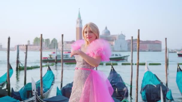 Красивая улыбающаяся блондинка перед венецианскими гондолами — стоковое видео