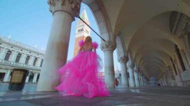 Venedik 'te San Marco meydanında pembe şık elbiseli bir kız.