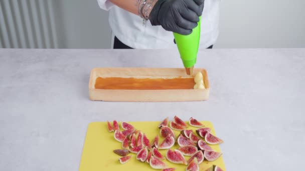 Person decorates biscuit with cream using piping bag — Stock Video