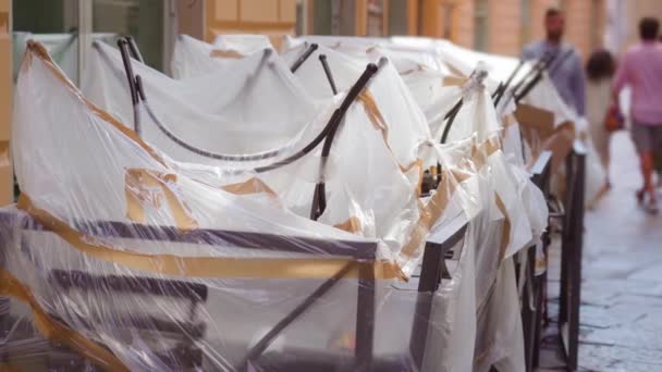 Cafe metalen tafels en stoelen bedekt met gescheurde plastic wrap — Stockvideo
