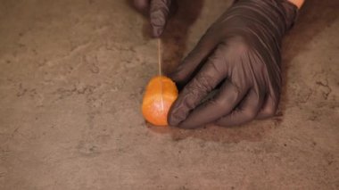 Eldivenli pasta şefi kekin ortasında kek kesiyor.