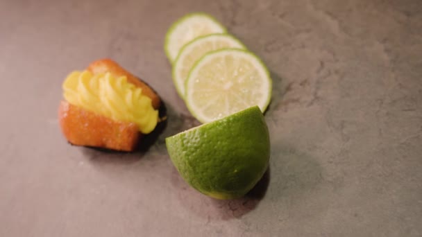 Färsk muffins med vaniljsås och skivad lime ligger på bordet — Stockvideo