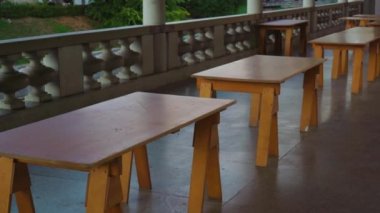 Ahşap kafe masaları Ljubljana 'da inşa terasında duruyor.
