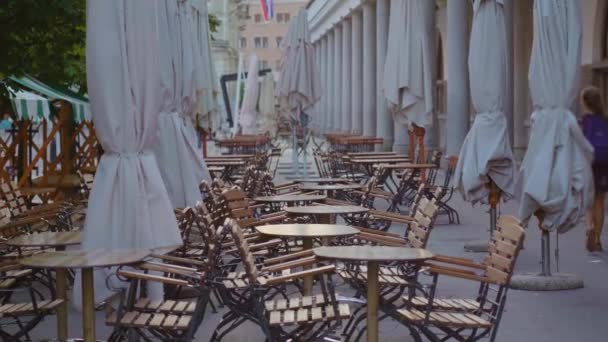 Rijen van houten tafels en stoelen staan in gezellige straat cafe — Stockvideo