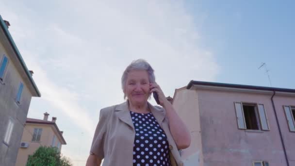 Mujer mayor habla por teléfono de pie en la calle en Chioggia — Vídeos de Stock