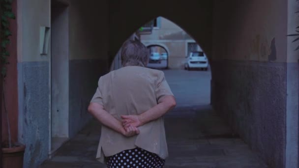 Elderly woman strolls through cosy courtyard of Chioggia — Stock Video