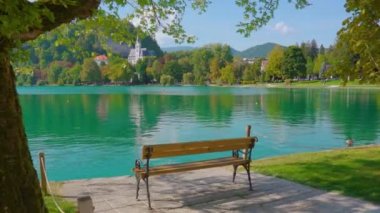 Bled Gölü 'ne karşı yeşil parkta duran tahta bank.