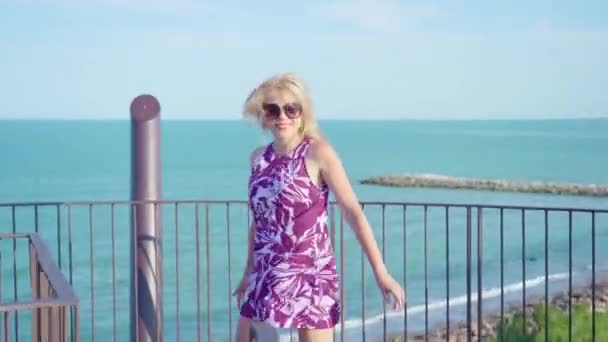 Chica feliz se mueve en una torre de observación frente al mar — Vídeos de Stock