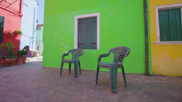 Calle con sillas de plástico en el patio de la sombra en Burano — Vídeo de stock