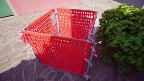 Recinzione in plastica rossa del tombino fognario nella soleggiata via Burano — Video Stock
