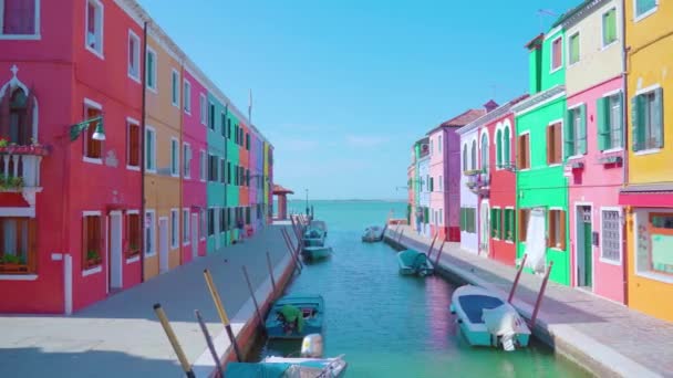 좁은 석호 운하 둑에 줄지어 있는 밝은 색깔 의집들 — 비디오