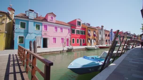 Maisons debout le long du canal d'eau avec des bateaux et un pont — Video