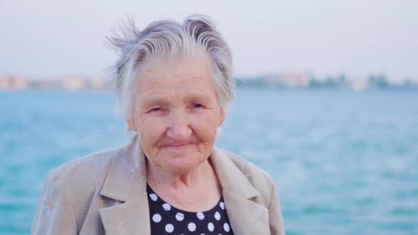 Senior dame reiziger kijkt in de camera staande op de promenade — Stockvideo