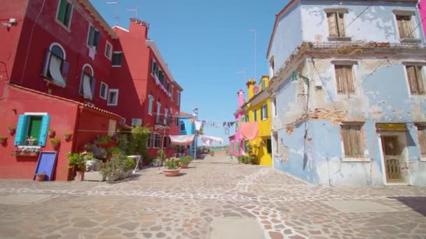Calle con ropa secándose en el viento entre casas coloridas — Vídeos de Stock