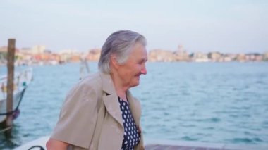 Yaşlı bayan gezgin Chioggia 'da gezinirken gülümsüyor.
