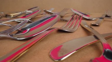 Karton kutuya saçılmış paslanmaz çelik sofra takımı.