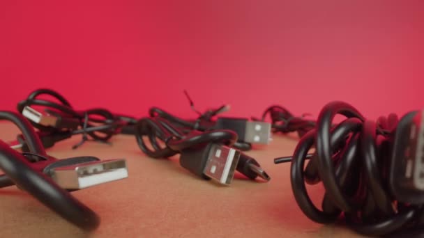 Fili di cavi USB in confezioni originali sul tavolo a parete rosa — Video Stock