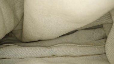 Düzgün katlanmış sarı dikişli açık renk kot pantolon ve düğme.