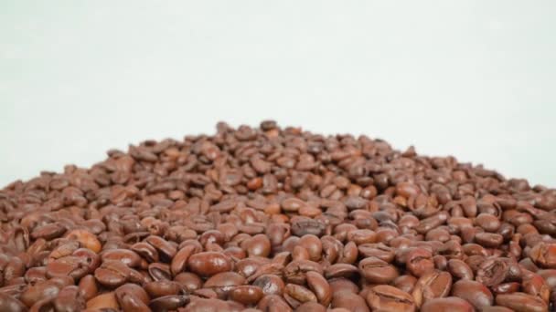 Montón de granos de café sobre fondo blanco de la habitación del estudio — Vídeo de stock