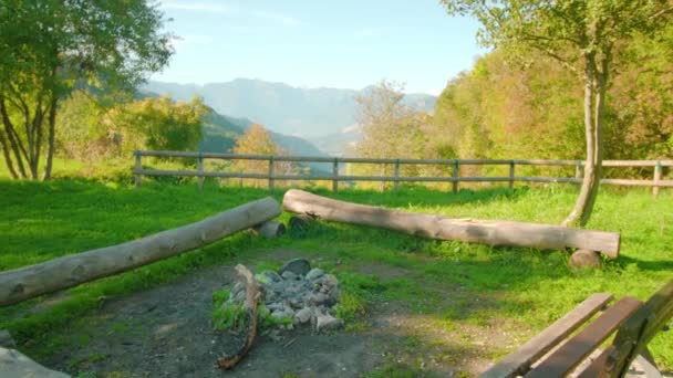 Bench en zitplaatsen van houtblokken rond kampvuur in park — Stockvideo