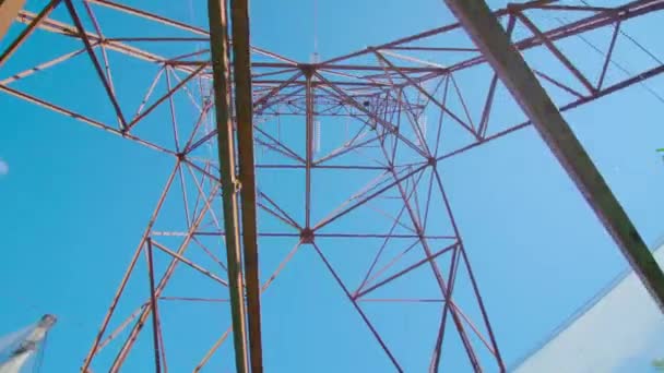 Torre de línea de transmisión eléctrica se levanta contra el cielo azul — Vídeos de Stock