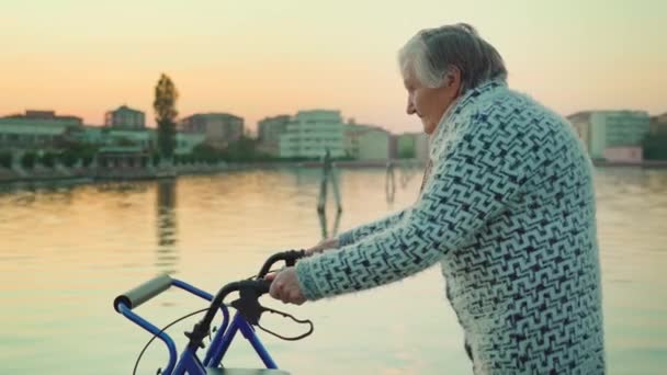 Vieja camina cerca de la laguna de Venecia con silla de ruedas-rollator — Vídeos de Stock