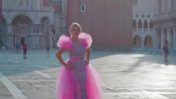 Belle fille blonde avec robe rose sur la place San Marco — Video