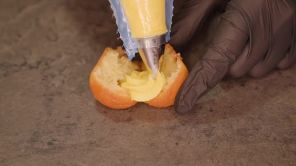 Pastelero aplica crema en magdalena acostado en la mesa — Vídeos de Stock