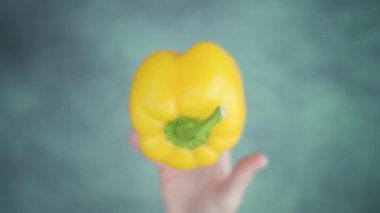 Kusuyor ve masanın üstündeki sarı çan biberini yakalıyor.